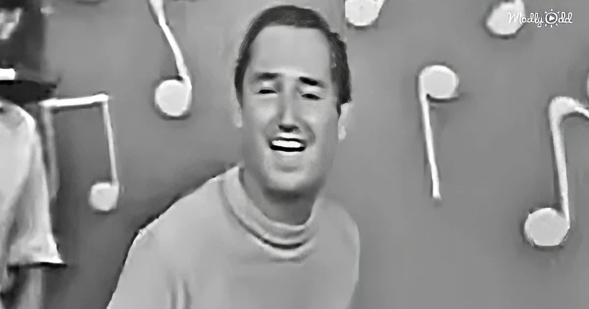 A man in a turtleneck smiles, surrounded by musical notes on a gray background.