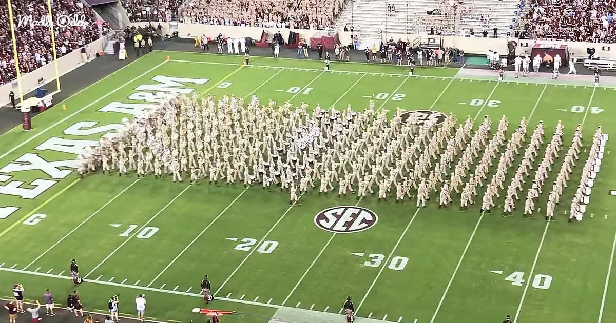 A marching band in uniform formations on a football field with the SEC logo.