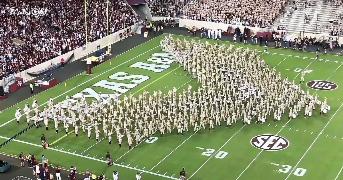 A marching band in uniform forms a large "T" on a football field with "Texas A&M" displayed.