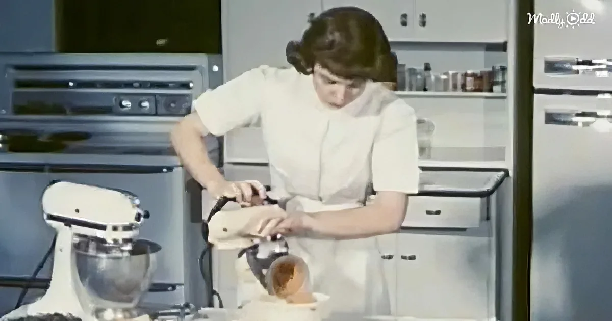 A woman in a white dress pours flour into a bowl in a retro kitchen.
