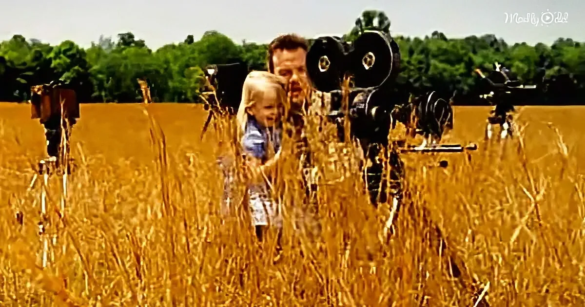 A man and child peek through a wheat field, surrounded by mechanical figures.