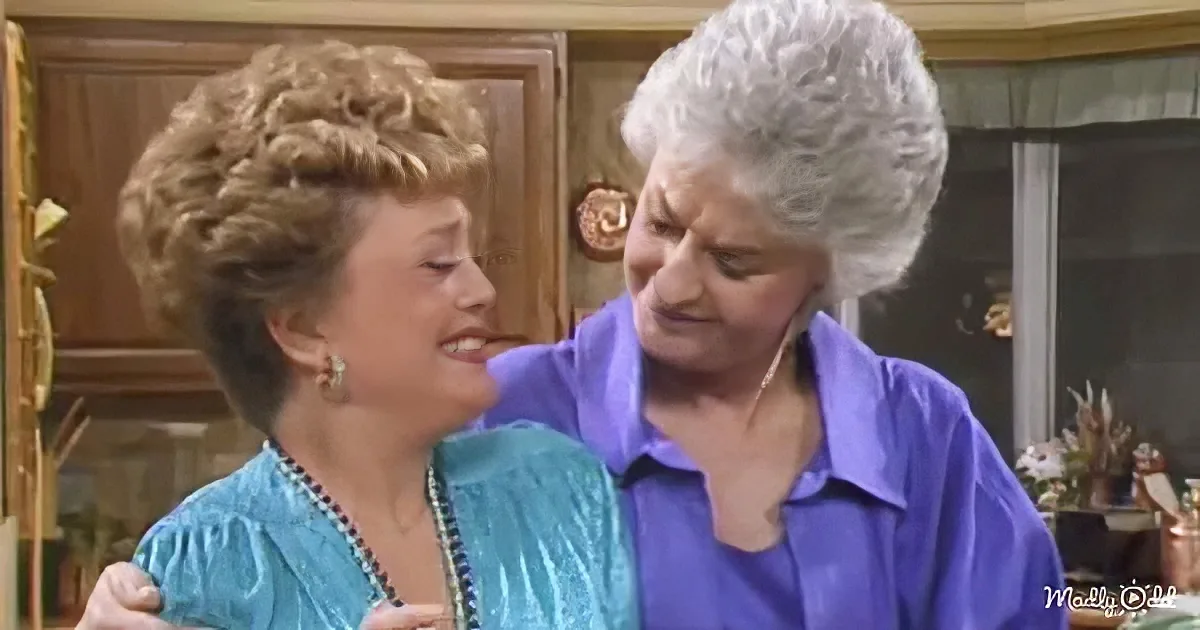 Two women, one in blue, embrace warmly in a cozy indoor setting.