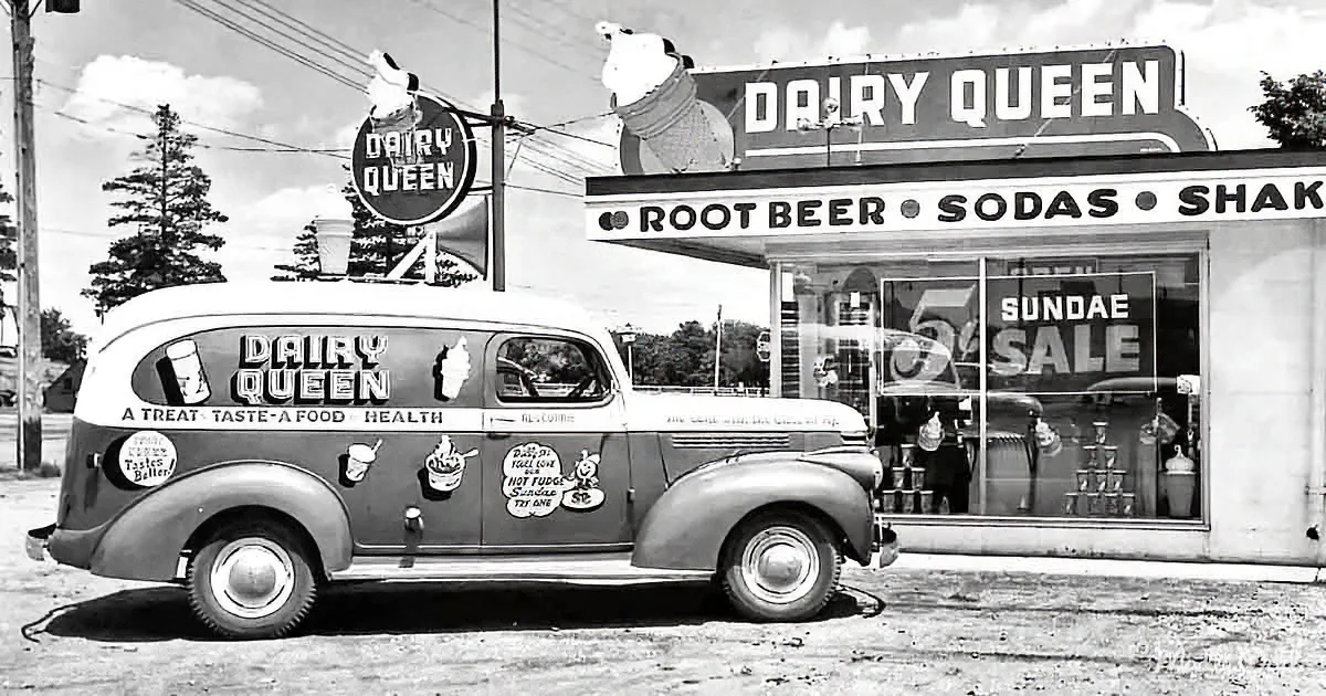 A vintage Dairy Queen delivery van parked in front of a classic Dairy Queen ice cream shop.