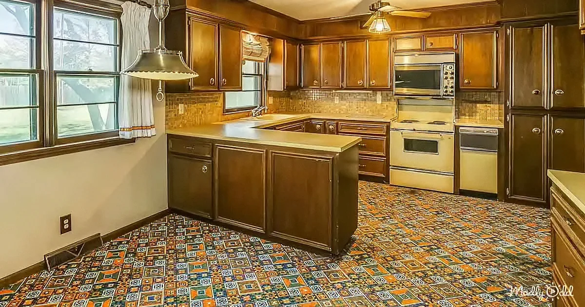 A retro kitchen with brown cabinets, patterned floor, and vintage appliances.