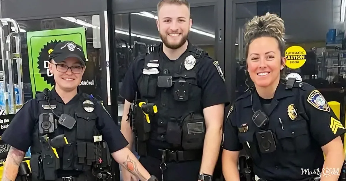 Three police officers in uniform stand together, smiling, with one wearing a cap and another a sergeant's badge.
