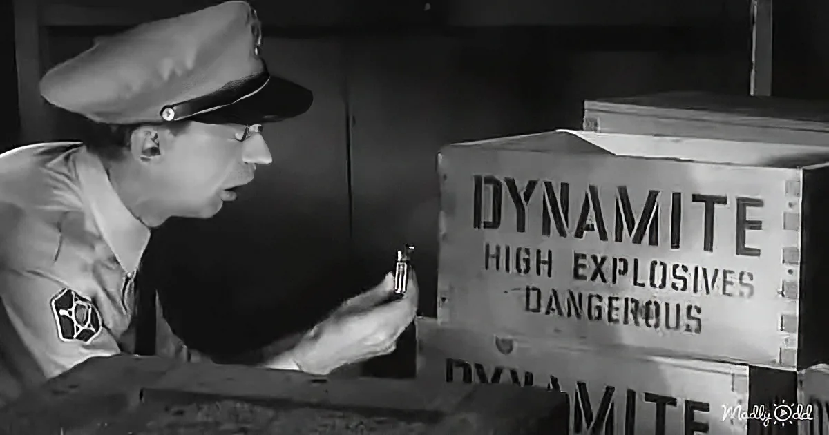 A man in a uniform inspects a dynamite box labeled "High Explosives Dangerous."