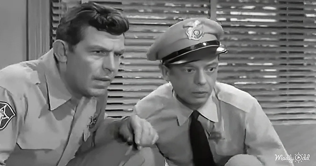 A man in a uniform leans on another man in a police uniform, both looking concerned.