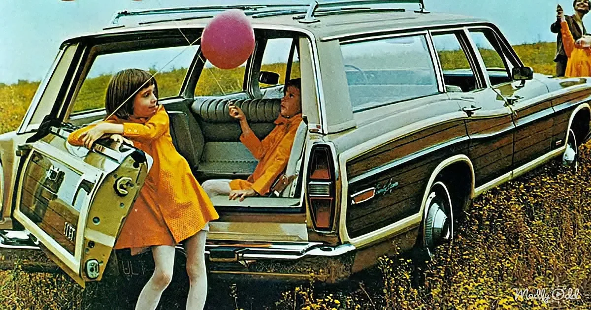 Two children in orange play with a pink balloon beside a vintage station wagon in a field.