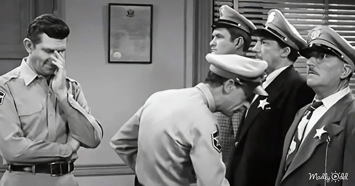 A man in a sheriff's uniform is covering his face, while others in uniform stand behind him, appearing concerned.