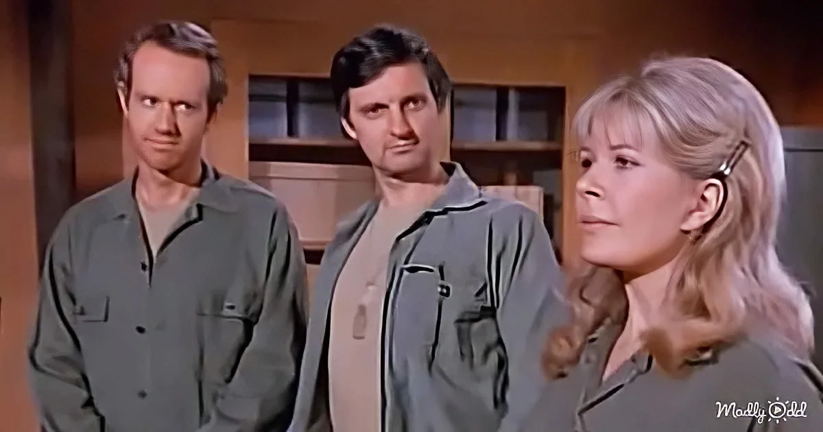 A woman with blonde hair looks to the side, flanked by two men in similar attire.