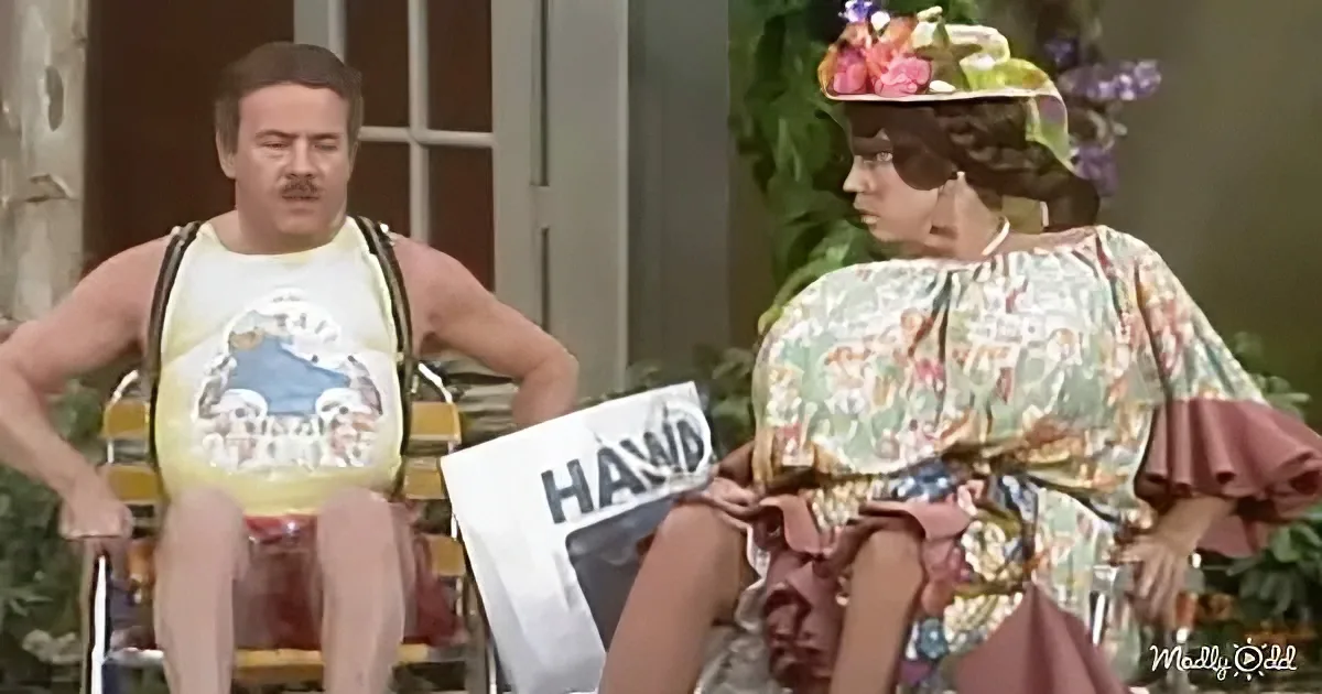 A man in a yellow tank top and a woman in a floral dress are seated, with the man holding a sign that reads "HAWA."