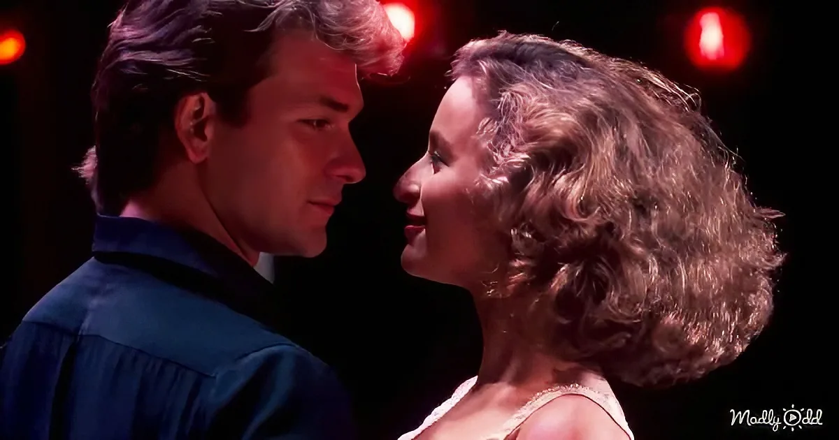A man and woman face each other closely, illuminated by red lights, suggesting a romantic or intimate moment.