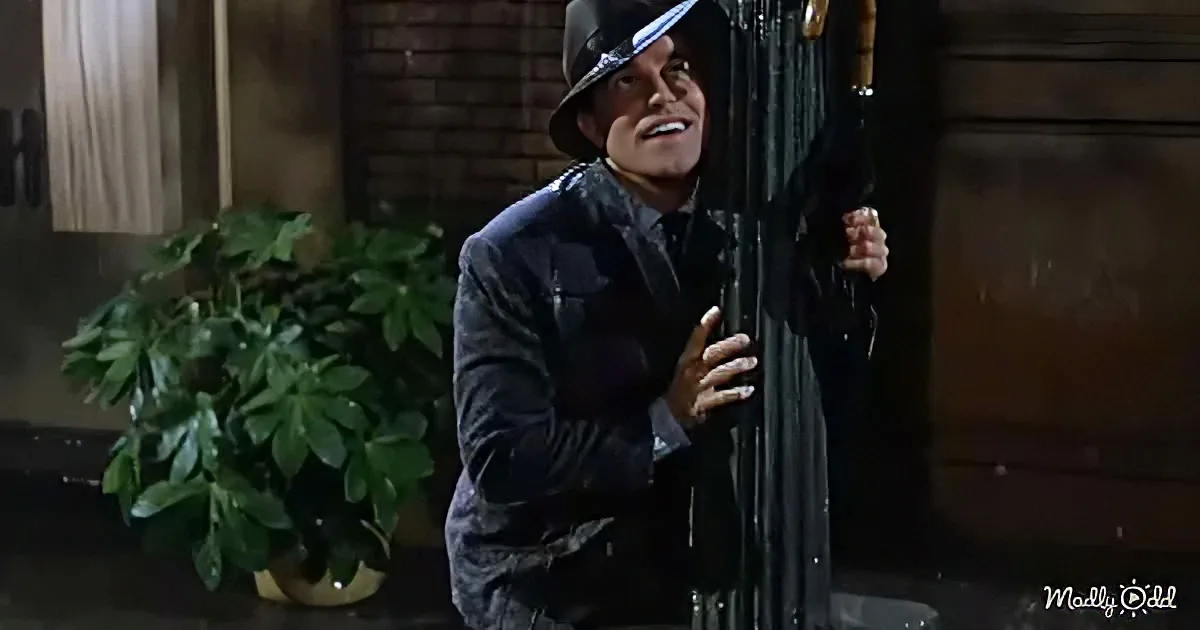 A man in a dark suit and hat is holding a cane, appearing to be in a dramatic or emotional scene.