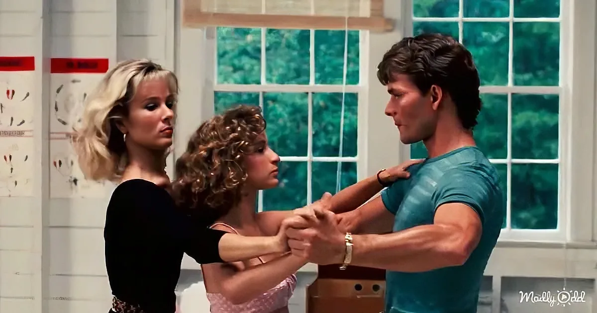 A man in a blue shirt holds hands with two women, one in a black top and the other in a pink dress, in a room with windows.