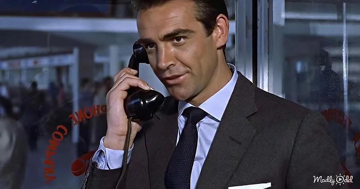 A man in a suit and tie is holding a telephone to his ear, appearing to be in a conversation.