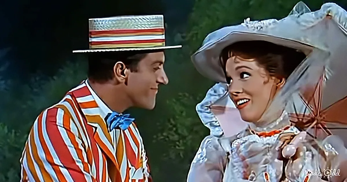 A man in a striped suit and top hat smiles at a woman in a silver outfit with a large hat.