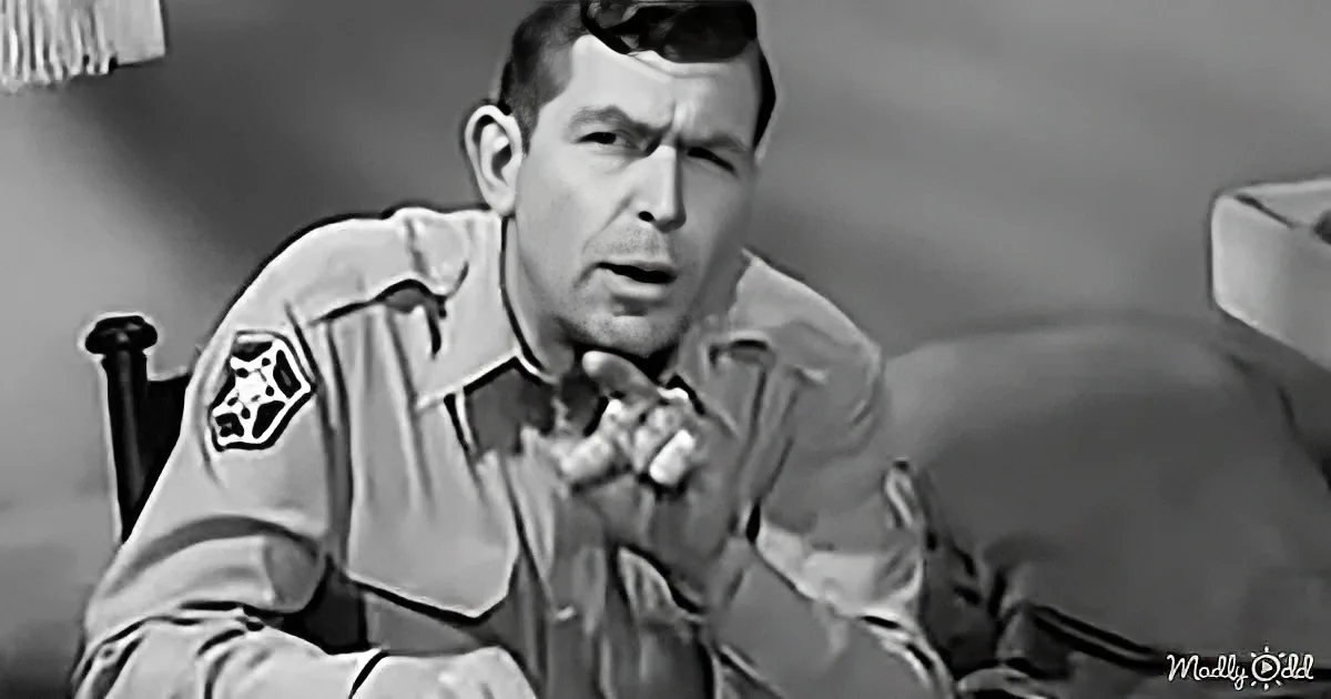 A man in a military uniform sits with clasped hands, appearing concerned or thoughtful.
