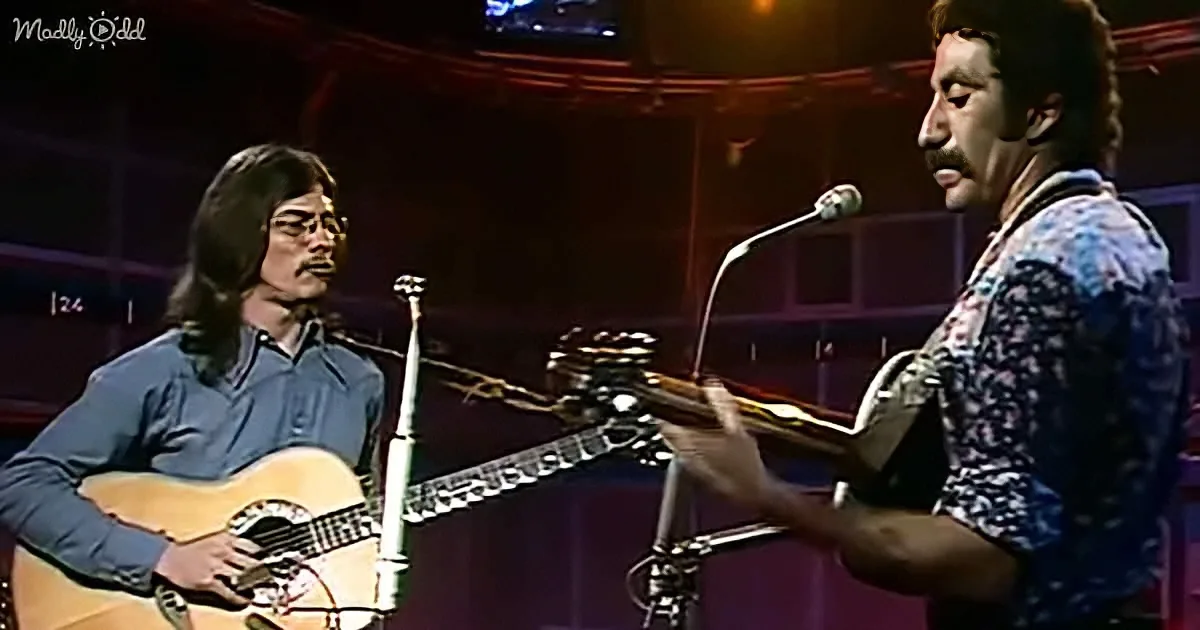 Two musicians perform on stage, one playing guitar, the other singing into a microphone.