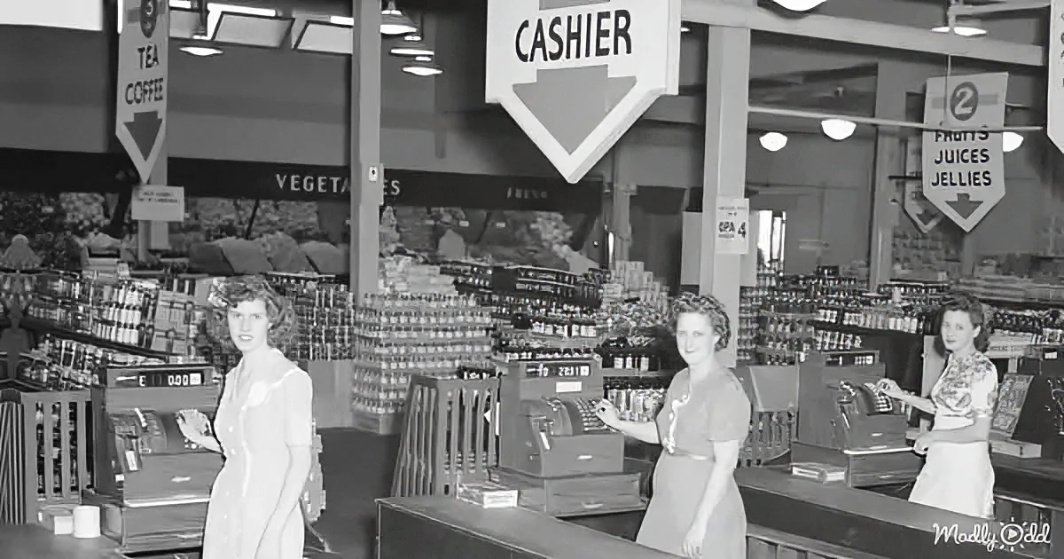 Cashier area in a vintage grocery store with women at counters and shelves of products.