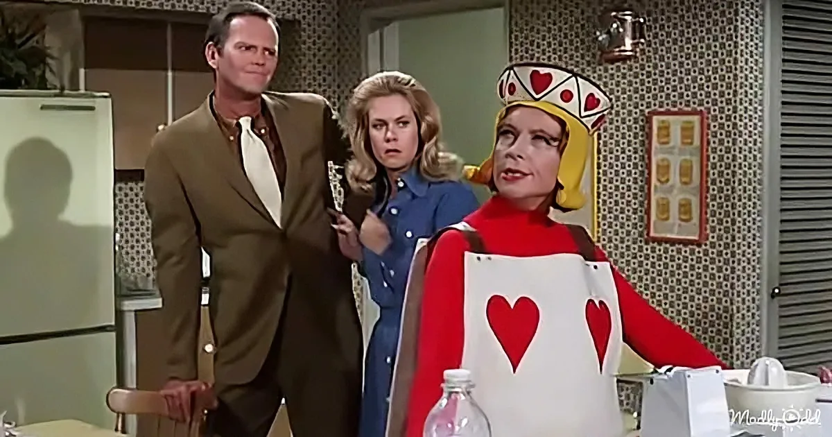 A person dressed as the Queen of Hearts stands in a kitchen, surrounded by two others, with a vintage aesthetic.