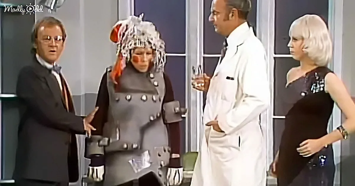 A person in a futuristic outfit stands between two men and a woman in a lab coat and black dress.