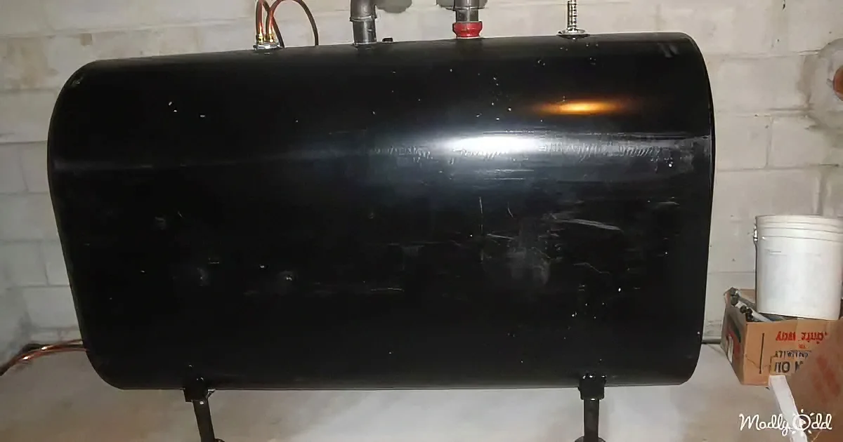 A black cylindrical water heater with visible pipes and screws is mounted on a stand.