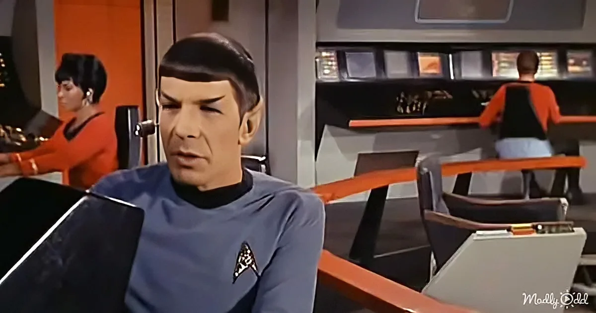 Spock in a Starfleet uniform sits at a console, surrounded by other crew members in a futuristic setting.