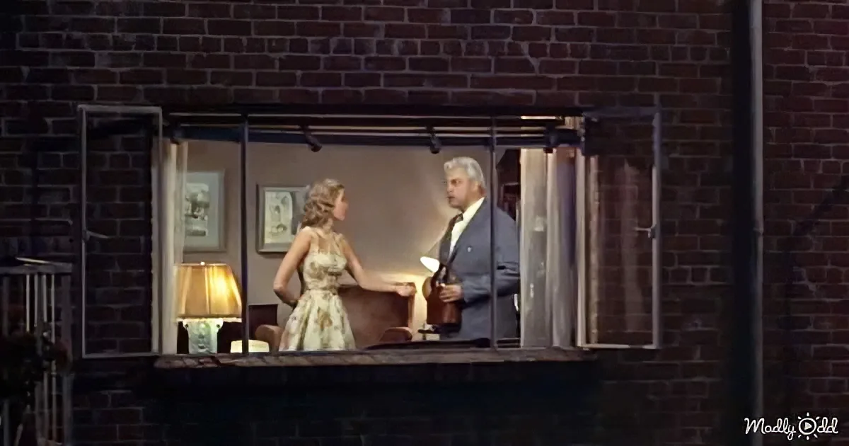 A woman in a dress stands by a man in a suit in a window, both facing each other.