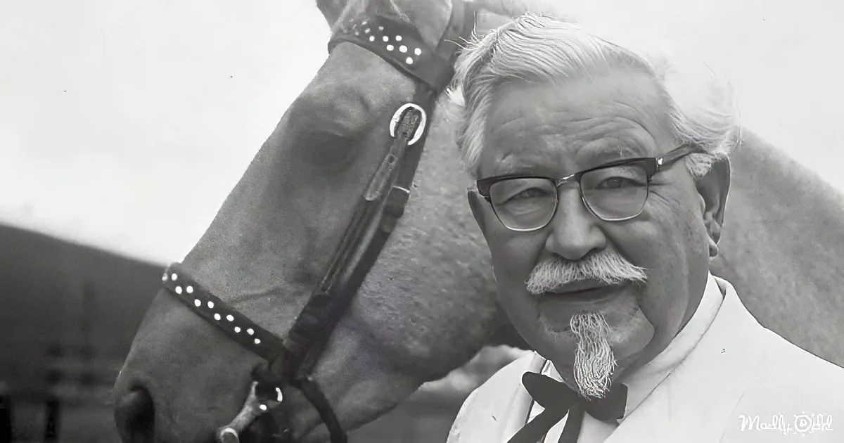An older man with a white beard and glasses stands next to a horse wearing a bridle.