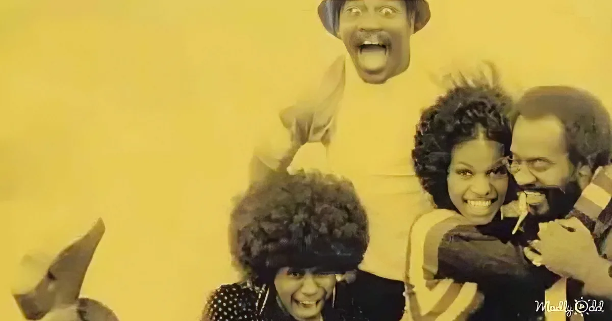 A group of people posing together, smiling and laughing, with a yellow background.