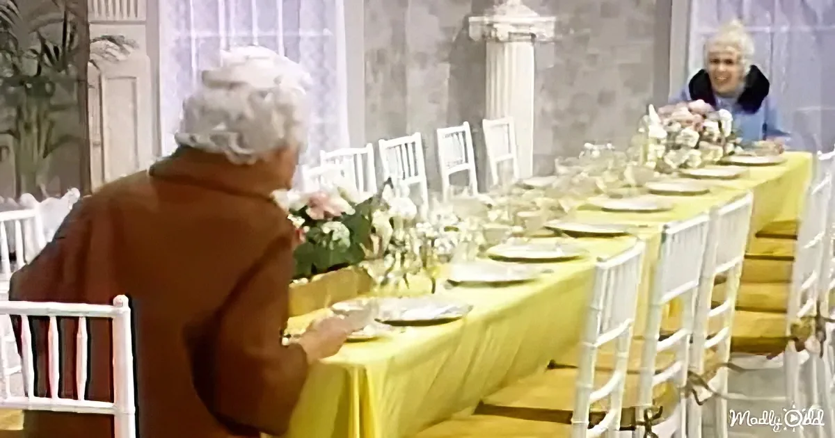 An elderly person sits at a long table with yellow tablecloth, surrounded by white chairs and floral decorations.