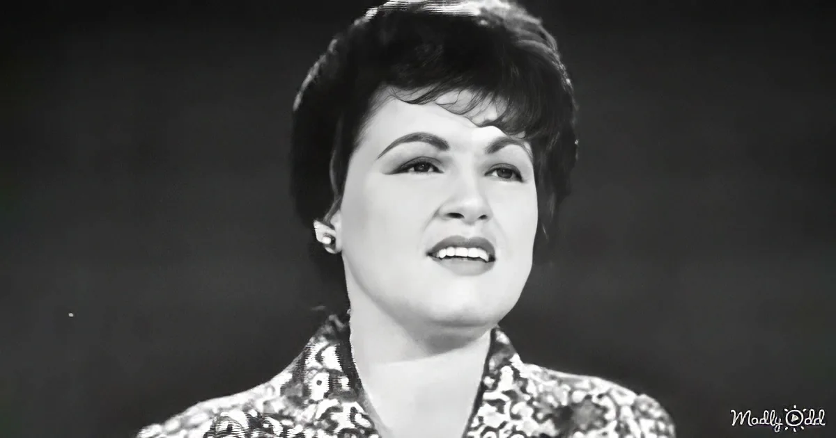 A woman with short hair, wearing a patterned top, is captured in a black-and-white image.