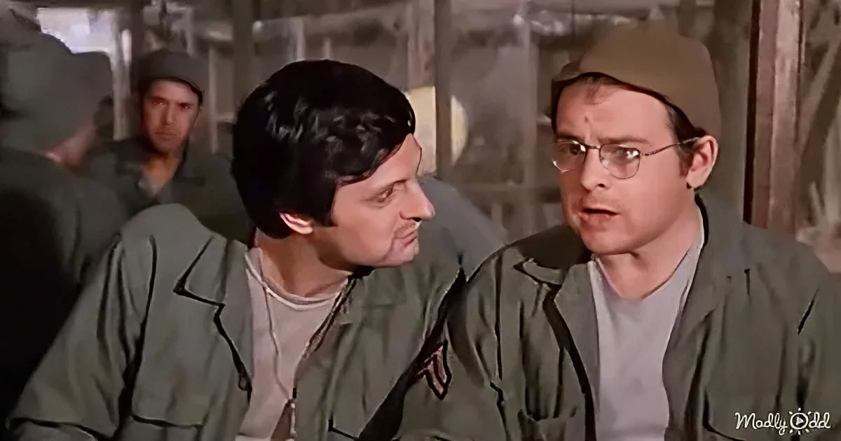Two men in military uniforms are engaged in a conversation, with one gesturing while the other listens attentively.