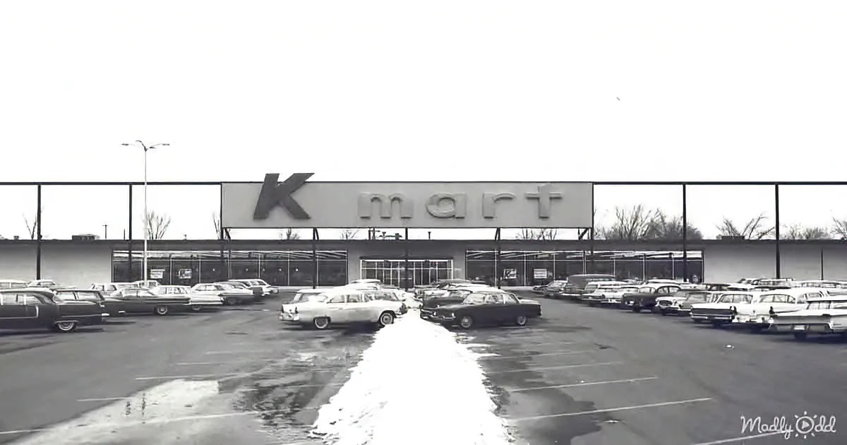 A vintage Kmart store with a large parking lot filled with classic cars.