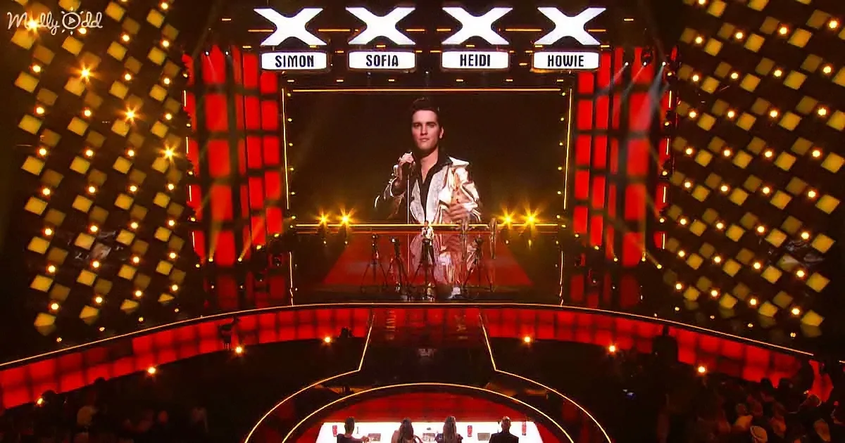 A large screen displays a person in a white suit, with judges' names above and a red-lit stage below.