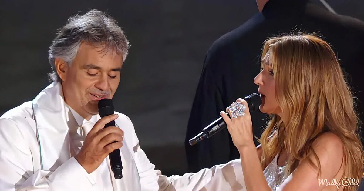 A man and woman in white sing into microphones, both focused on their performance.