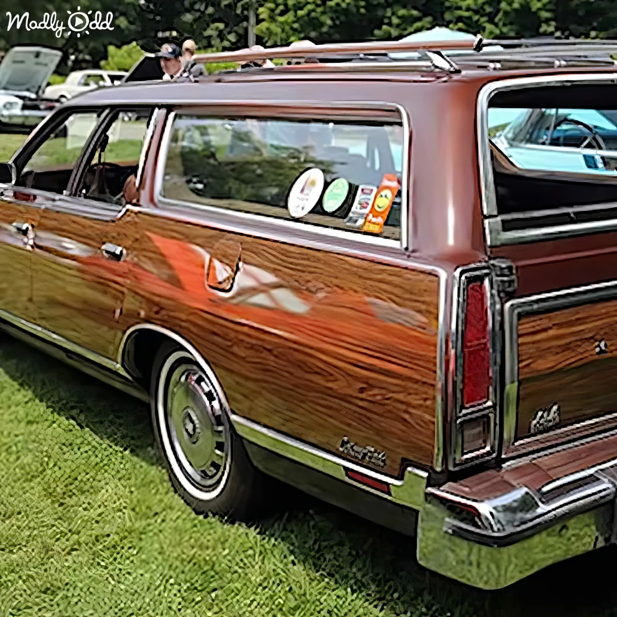 A classic brown station wagon with wood paneling and chrome details is parked on grass.