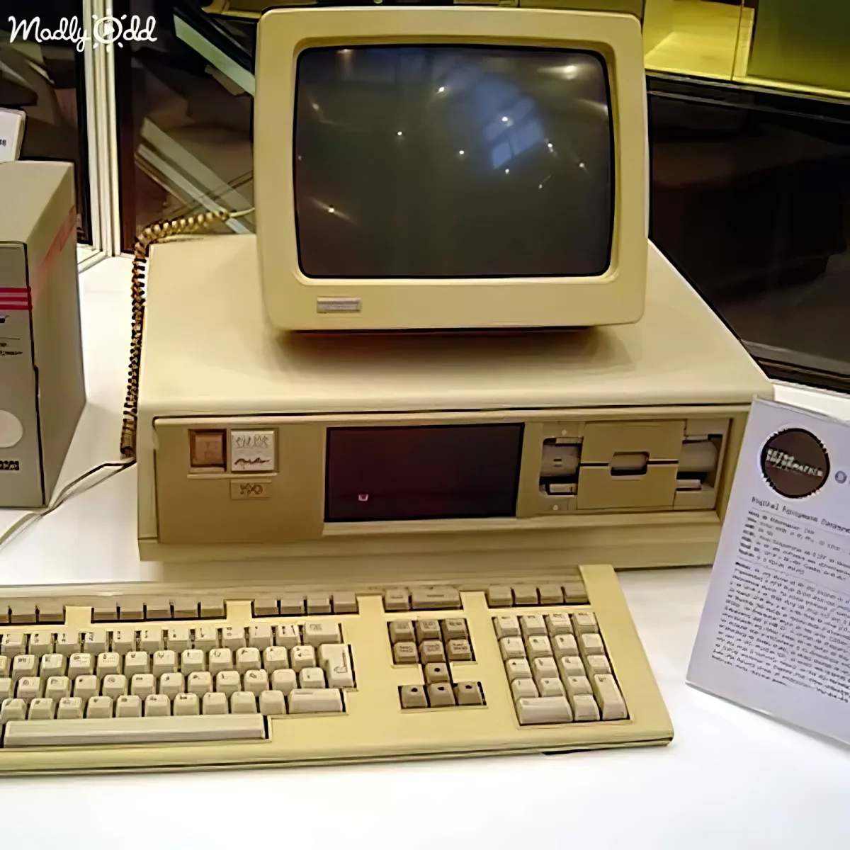 An old beige computer with a CRT monitor, keyboard, and floppy drives is displayed on a table.