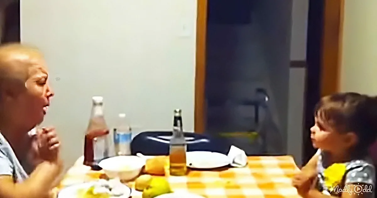 A woman and child sit at a table with food and drinks, engaged in conversation.