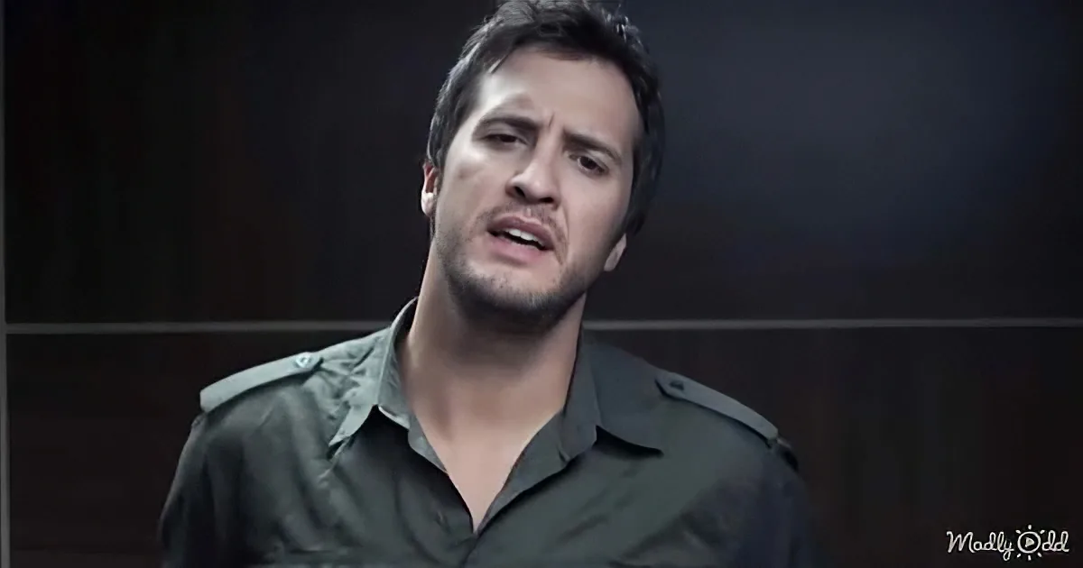 A man in a dark green shirt appears to be speaking or singing, with a serious expression.