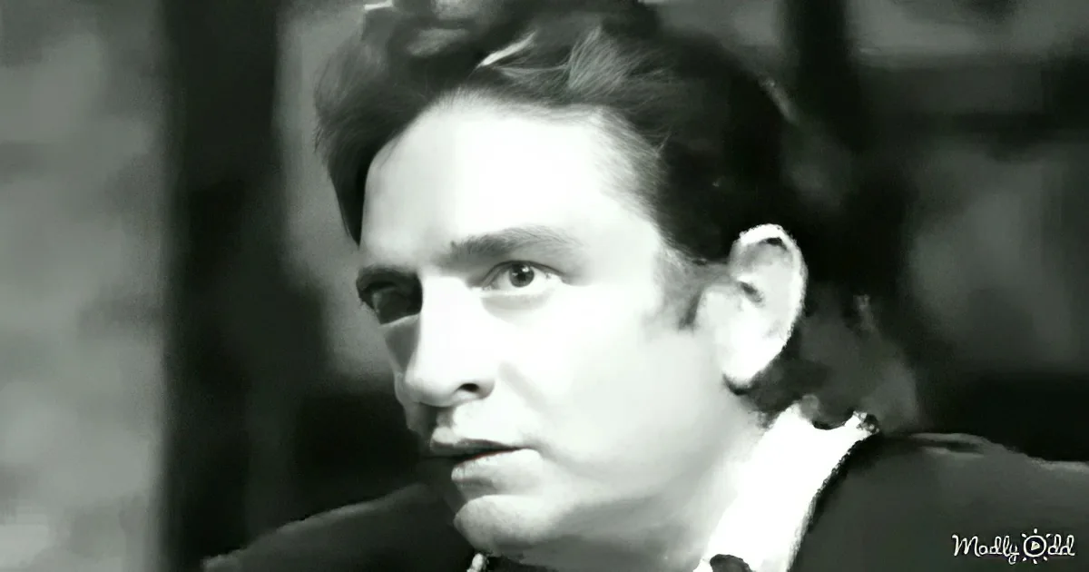 A man in a suit, looking to the side, with a serious expression, in a black-and-white image.
