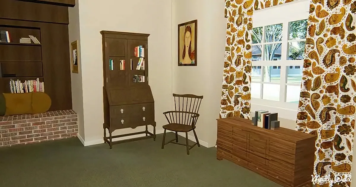A vintage-style room with a wooden secretary desk, chair, bookshelf, and paisley-patterned curtains.