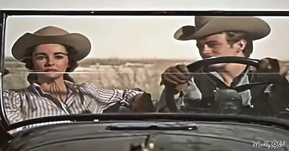 A man and woman in cowboy hats drive a vintage car, set against a desert backdrop.