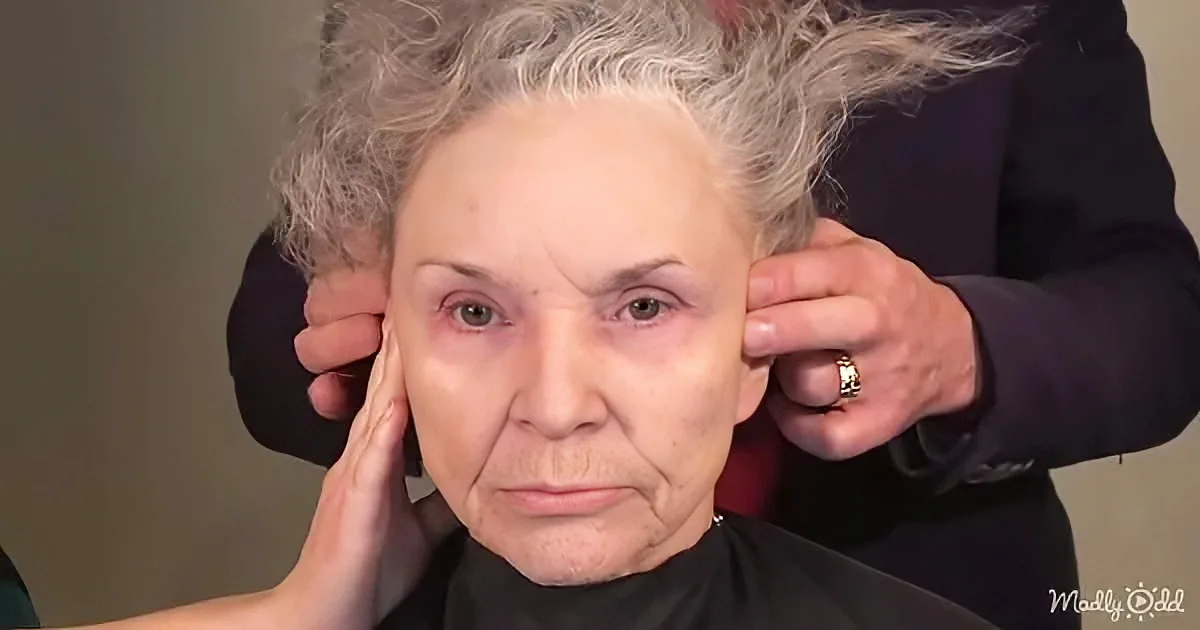 An elderly woman with gray hair is having her hair styled by a person in a black shirt.