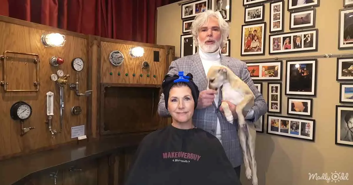 A woman sits in a salon chair, wearing a "MAKEOVER" sweatshirt, with a person holding a small dog and a vintage-style...