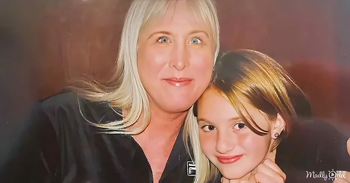 A woman with blonde hair and a young girl with short hair are smiling closely together.