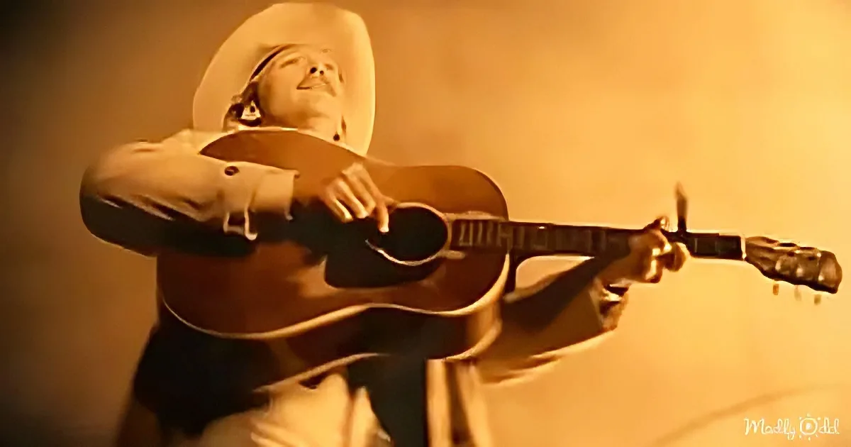 A man in a cowboy hat plays a guitar with a warm, sepia-toned background.