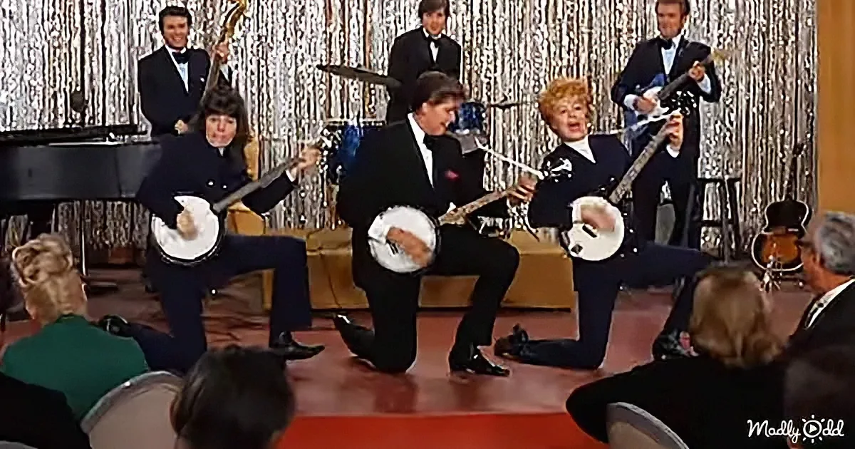 Banjo players in tuxedos perform on stage with a silver curtain backdrop.