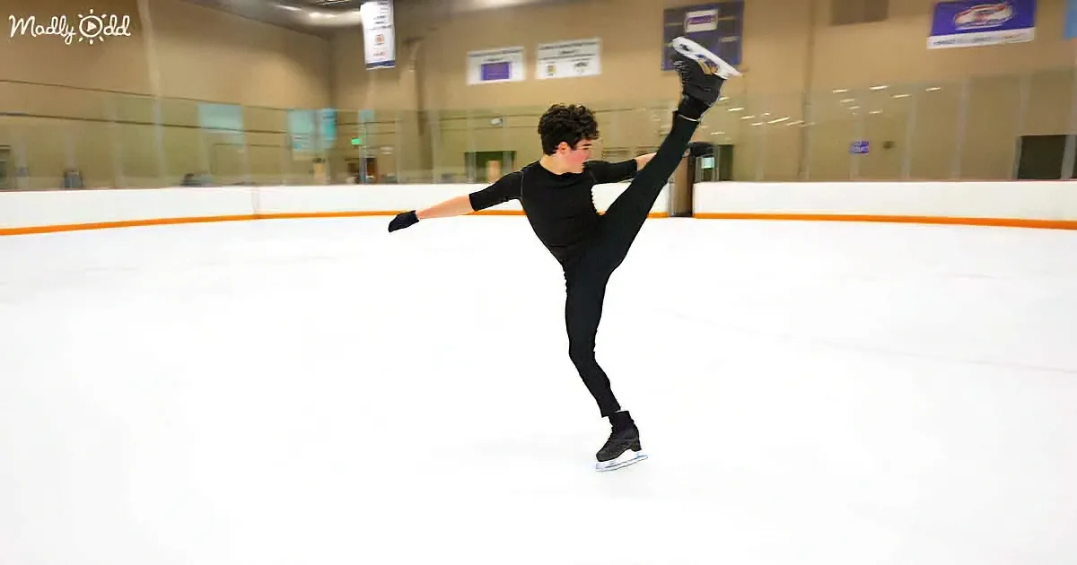 A figure skater in black attire performs a graceful pose on an ice rink.
