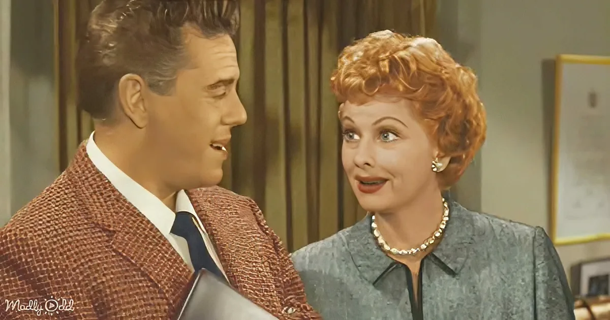 A man in a red plaid suit and a woman in a blue dress are engaged in conversation.